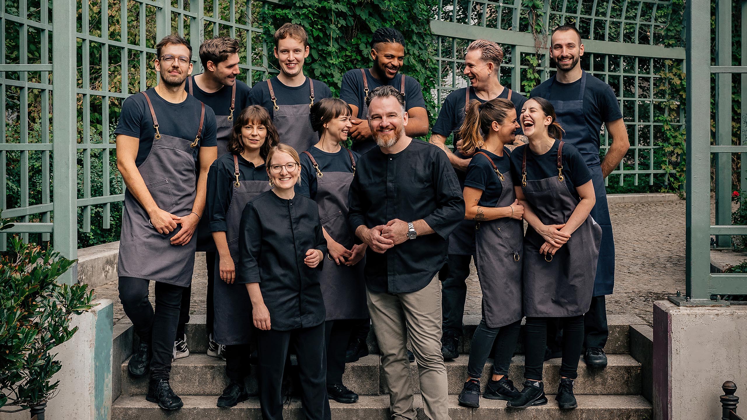 Das Coda Team steht vor einer Voliere im Park