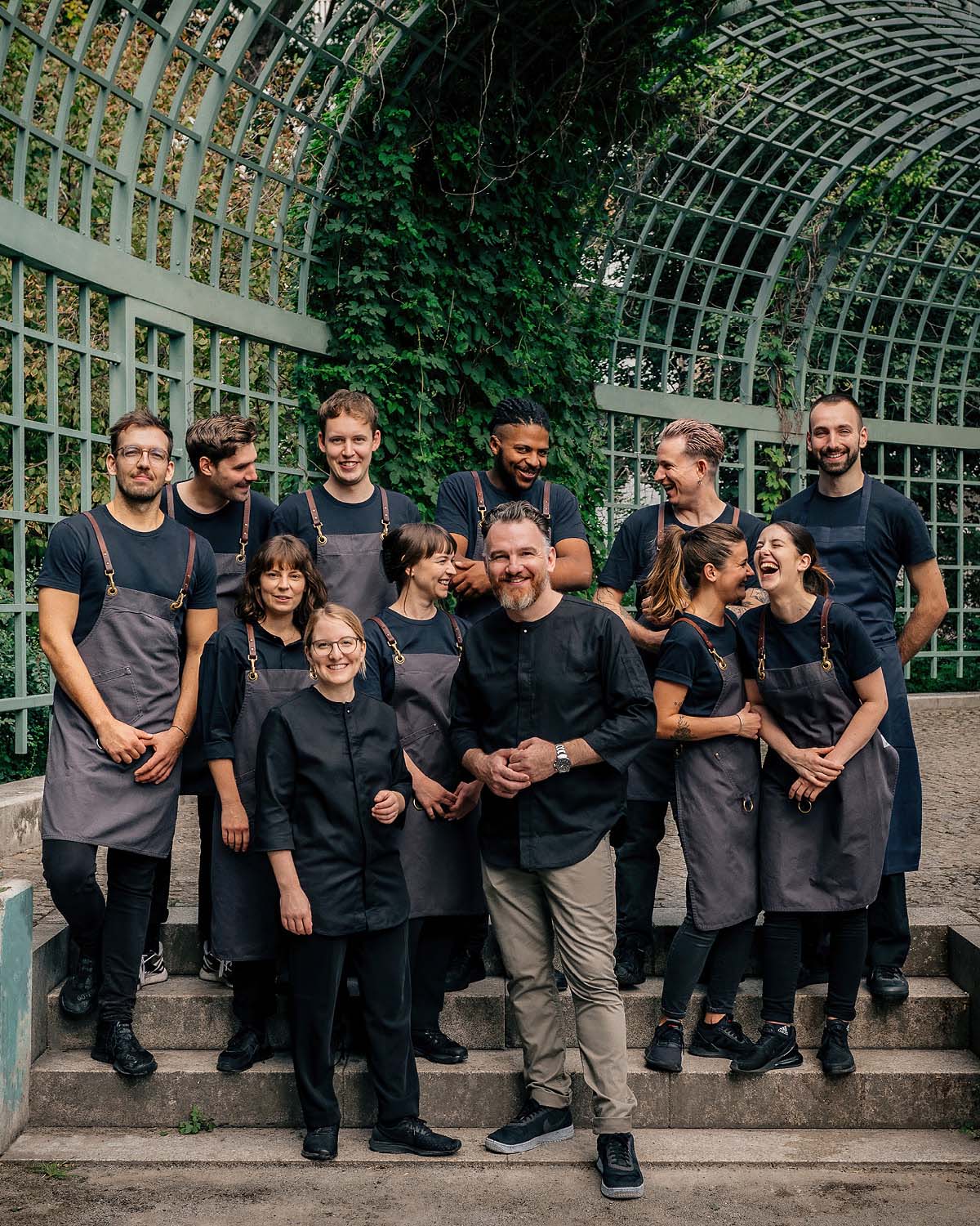 Das Coda Team steht vor einer Voliere im Park